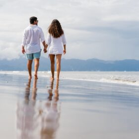 海岸を手を繋いで歩く恋人同士