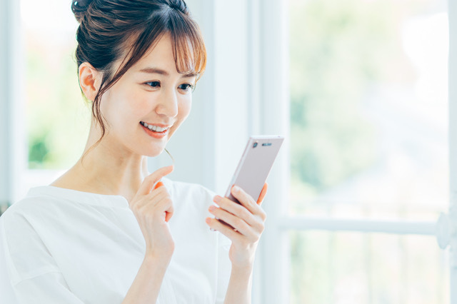 スマホでメッセージの確認をする女性
