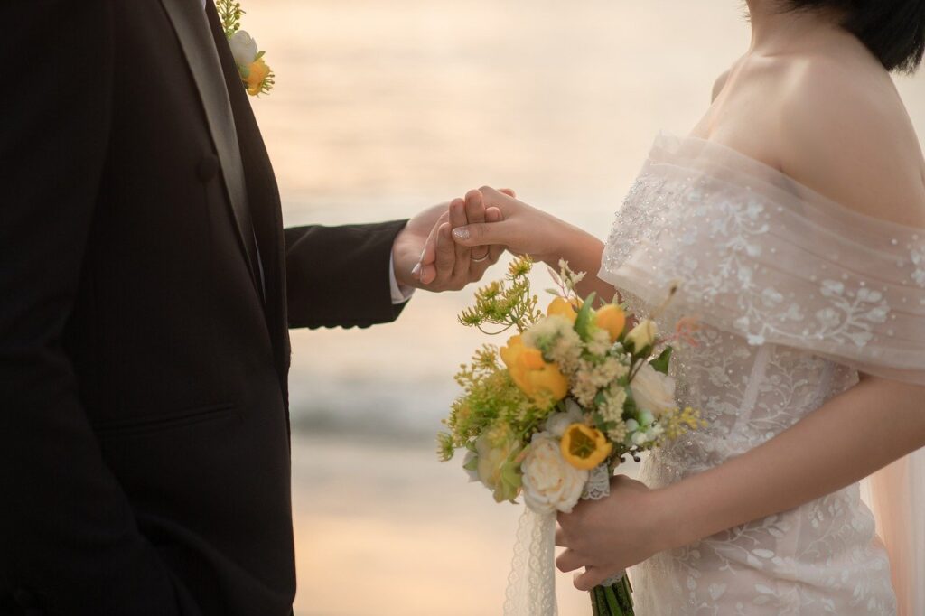 海辺で手を取り合う新郎新婦